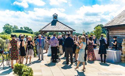 Guests enjoy drinks outside at this beautiful summer wedding venue