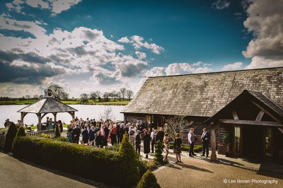 The Oak Barn is set up ready for the wedding ceremony and has been decorated in natural colours at this North West wedding barn