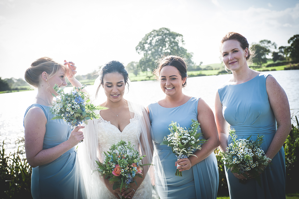 The bridesmaids wore pastel blue dresses with pretty bouquets of daisies and astilbe at this waterside wedding venue in Cheshire