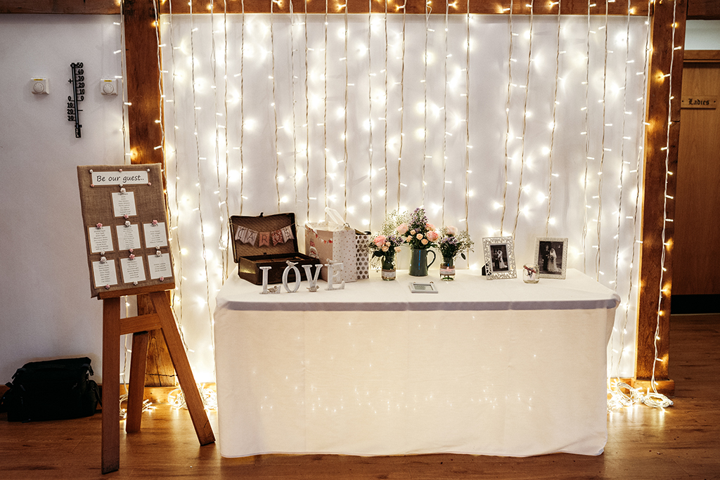 The card table decorated with pretty framed photos and a rustic wooden box for the wedding cards at Sandhole Oak Barn
