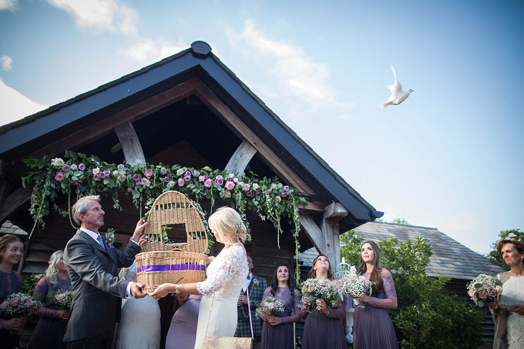 The bride and groom release doves after their outdoor wedding ceremony at Sandhole Oak Barn