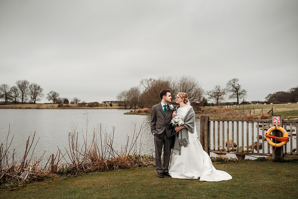 The happy couple have their wedding photos taken by the lake at this rural wedding venue in Cheshire 