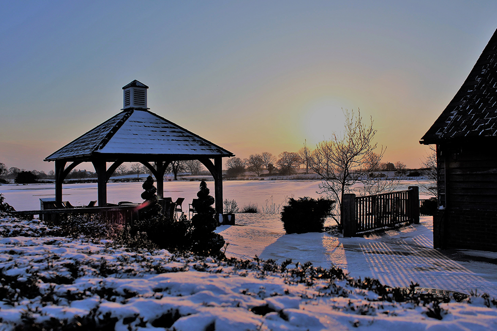 Sandhole Oak Barn looks beautiful in the snow with the sunset in the background
