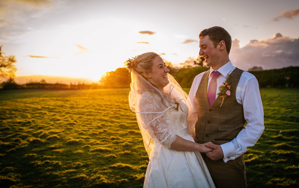 The happy newlyweds have their photo taken in the sunset at this rural wedding venue in Cheshire