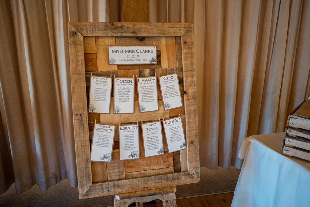 The table plan was displayed on a rustic wooden frame at this barn wedding near Manchester