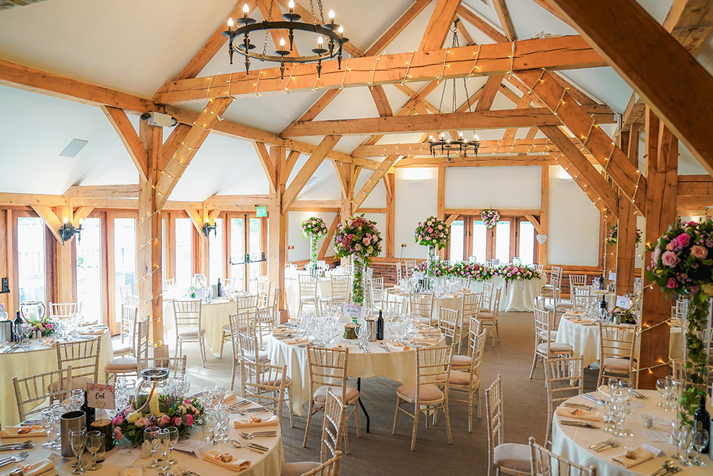 The oak barn at Sandhole Oak Barn was dressed with pretty pink flowers and fairy lights 