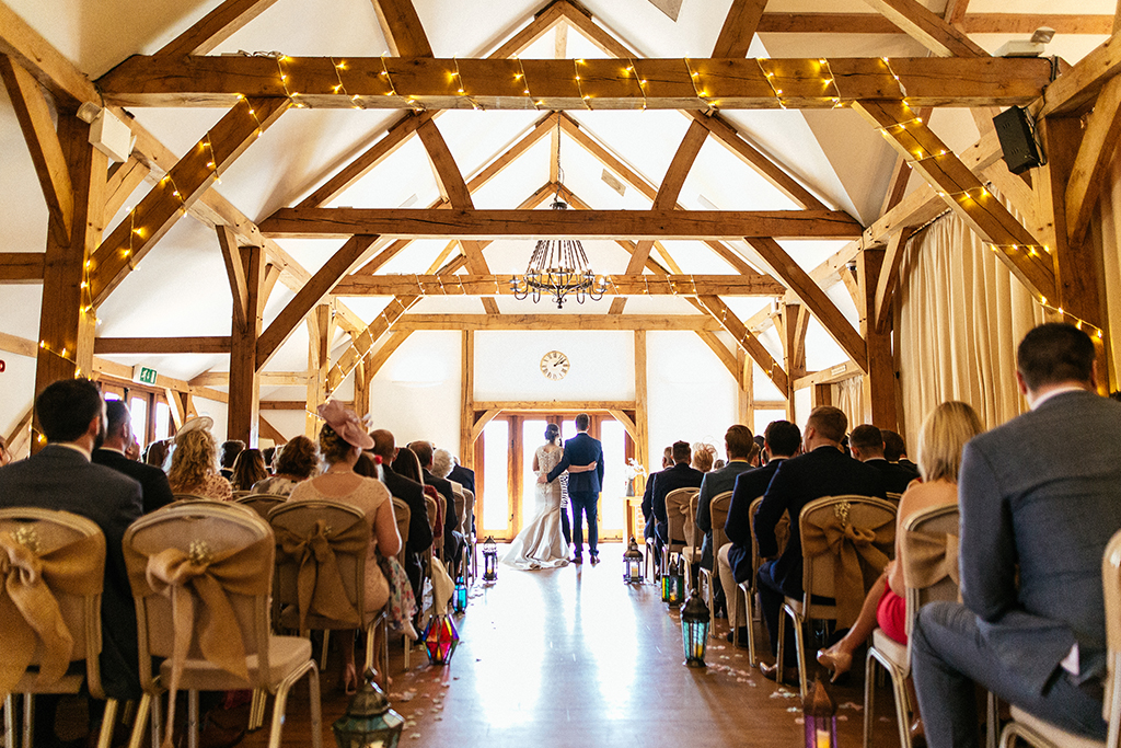 The bride and groom say their vows at their wedding ceremony at Sandhole Oak Barn in Cheshire
