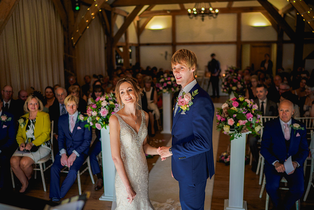 The bride and groom says their vows at Sandhole Oak Barn in Cheshire 