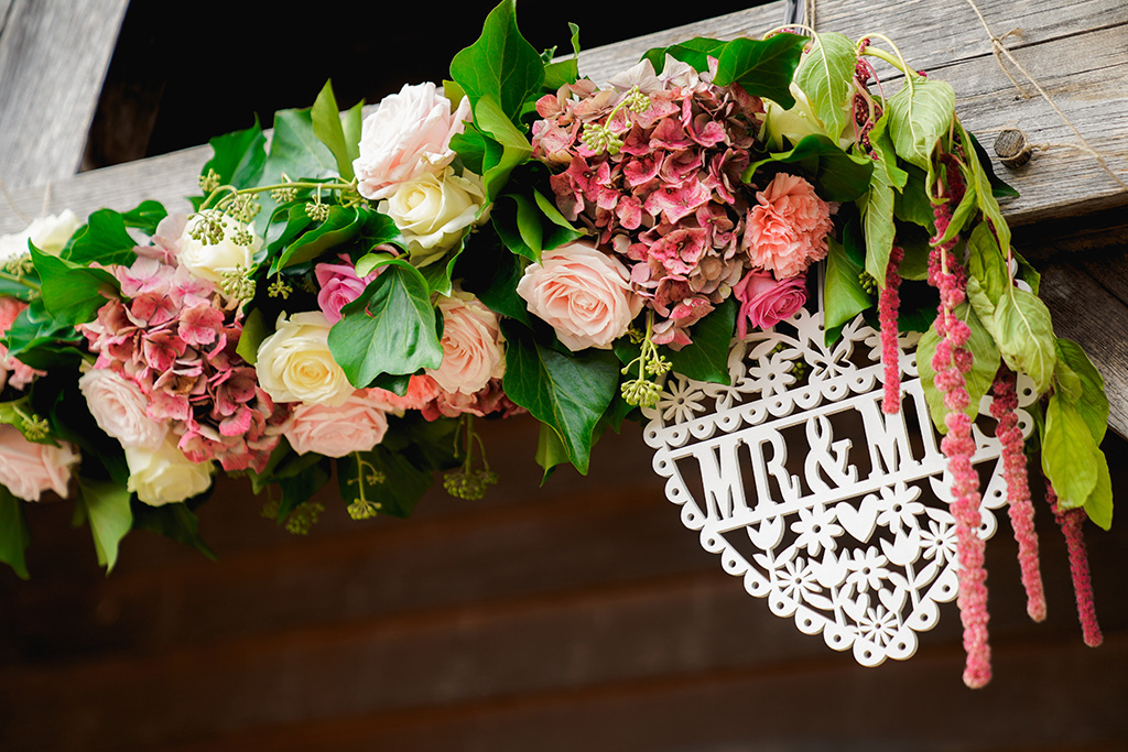 The wooden beams of the entrance to this Cheshire barn were decorated with garlands of pretty pink flowers 
